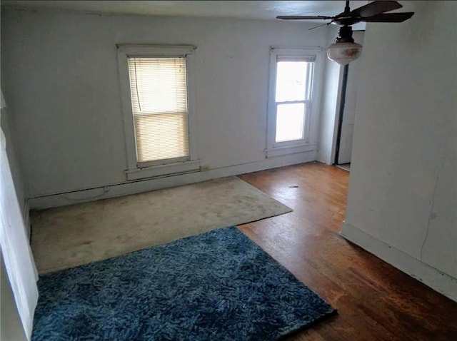 empty room with ceiling fan and wood finished floors