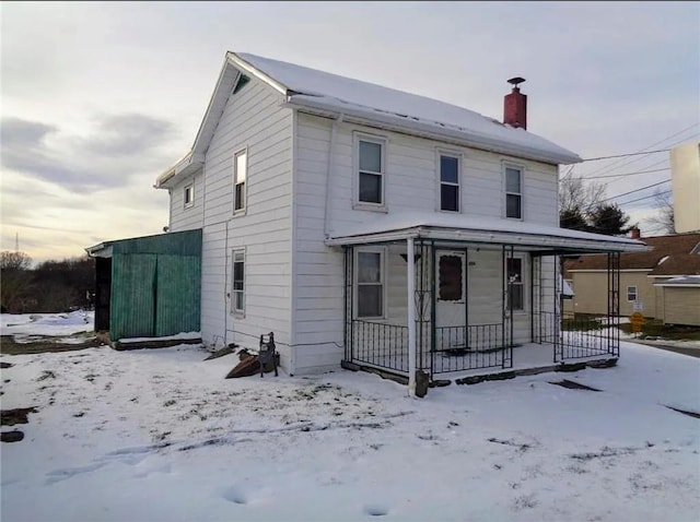 view of front facade with a porch and a chimney