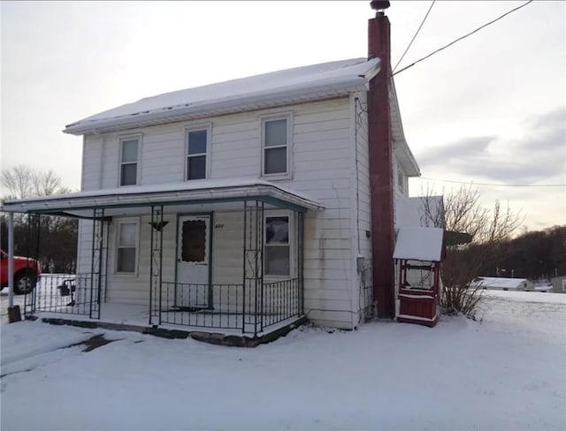 view of front facade with covered porch and a chimney