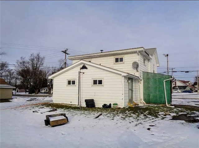 view of snow covered rear of property