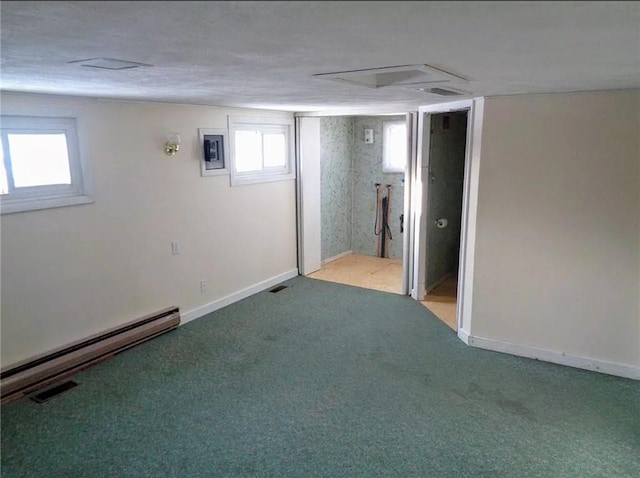 below grade area featuring carpet floors, a baseboard radiator, visible vents, and baseboards