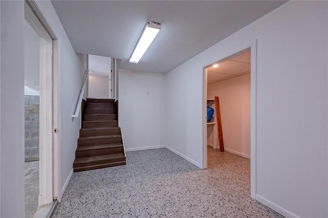 staircase featuring baseboards and speckled floor