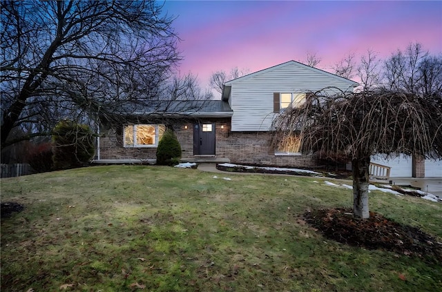 tri-level home featuring brick siding and a front yard