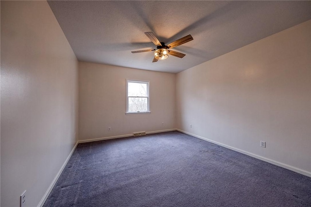 empty room with ceiling fan, dark carpet, and baseboards