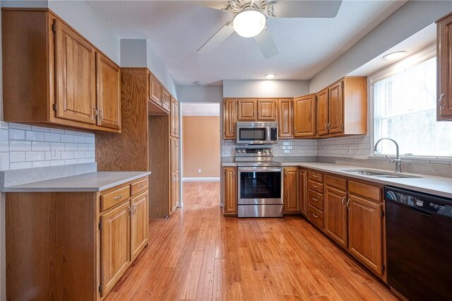 kitchen featuring appliances with stainless steel finishes, brown cabinets, light countertops, and light wood-style floors