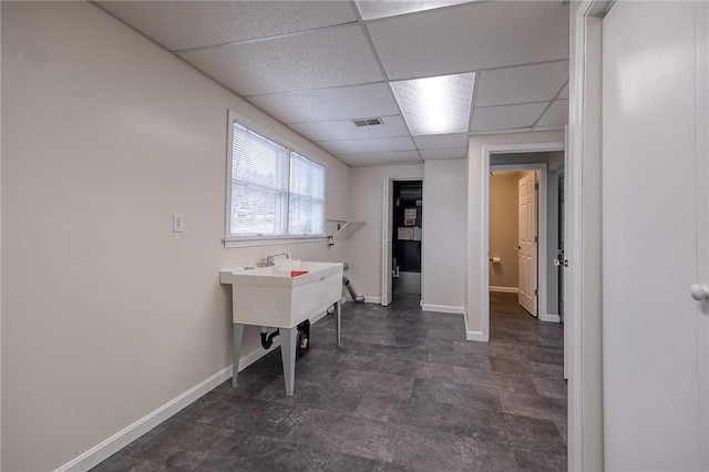 clothes washing area with visible vents and baseboards