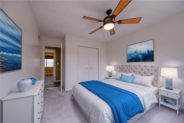 bedroom with light colored carpet, a ceiling fan, baseboards, visible vents, and a closet