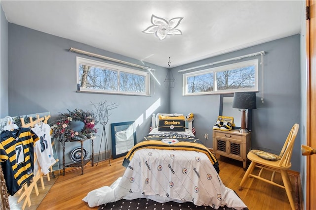 bedroom with baseboards and wood finished floors