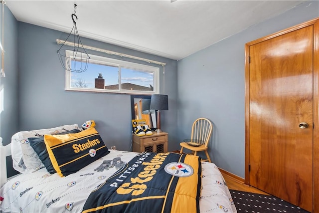 bedroom with wood finished floors and baseboards