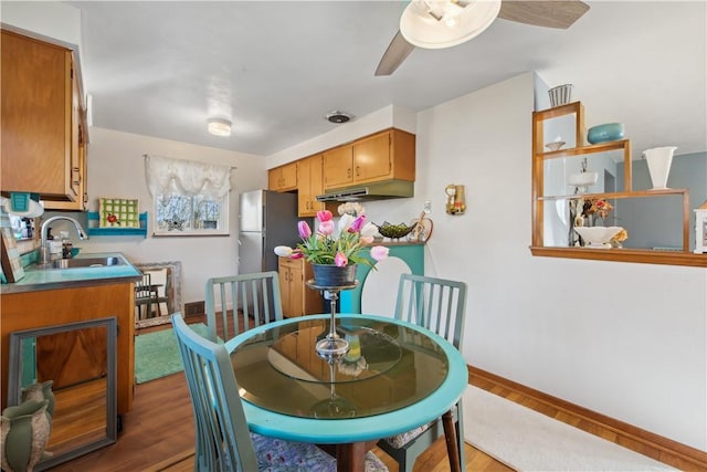 dining space with baseboards and wood finished floors