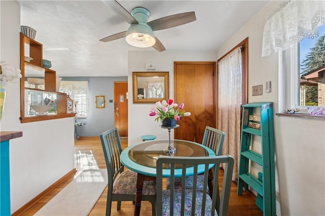 dining room featuring ceiling fan, baseboards, and wood finished floors