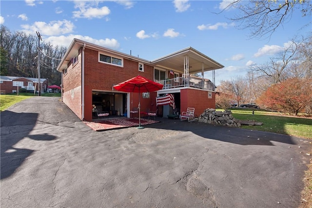 view of front of property featuring a garage, brick siding, and driveway