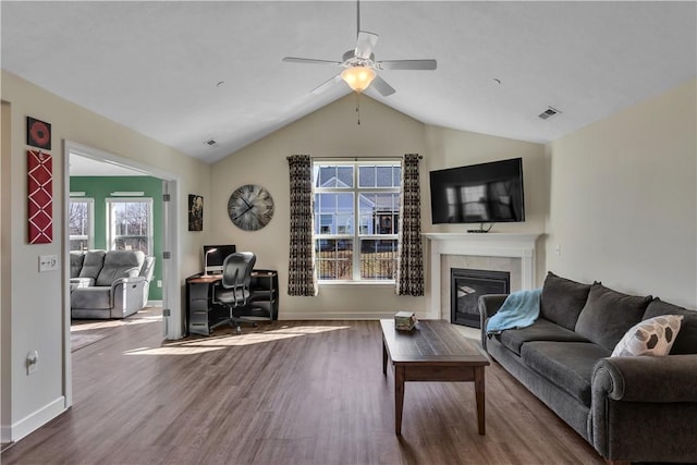 living room with a healthy amount of sunlight, visible vents, wood finished floors, and a glass covered fireplace