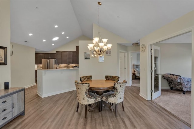 dining area with a notable chandelier, recessed lighting, vaulted ceiling, light wood-type flooring, and baseboards