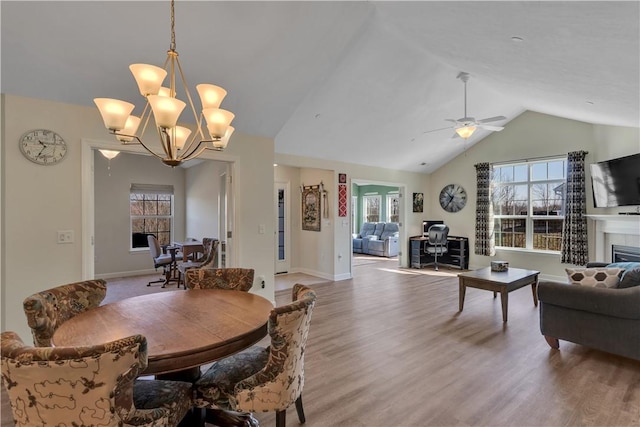 dining room with a wealth of natural light, light wood-type flooring, and vaulted ceiling