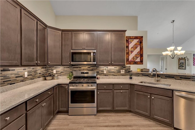 kitchen with light stone counters, a sink, dark brown cabinets, appliances with stainless steel finishes, and backsplash