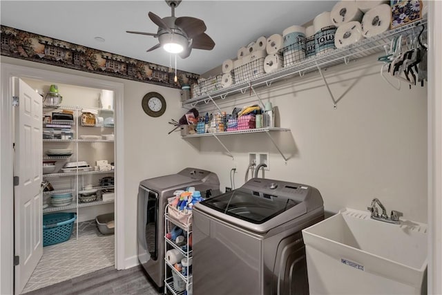 laundry room with a ceiling fan, a sink, wood finished floors, washer and dryer, and laundry area