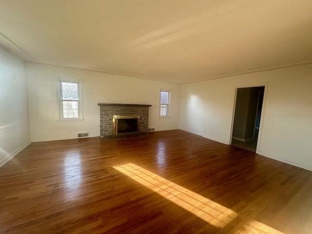 unfurnished living room featuring a fireplace, visible vents, and wood finished floors