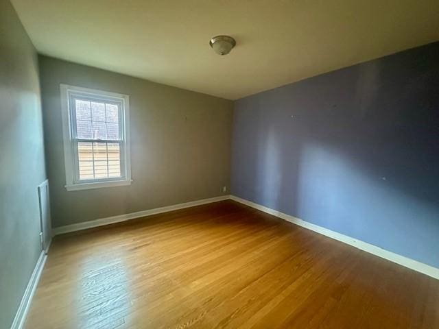 unfurnished room featuring baseboards and wood finished floors