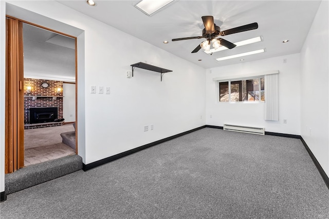 spare room featuring carpet, a fireplace, baseboards, and baseboard heating