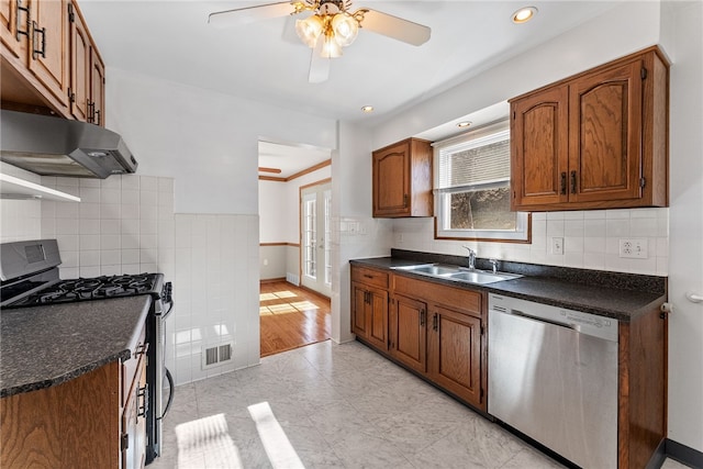 kitchen featuring visible vents, dark countertops, appliances with stainless steel finishes, under cabinet range hood, and a sink