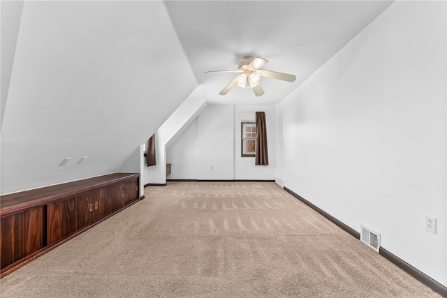 bonus room with carpet flooring, a ceiling fan, visible vents, vaulted ceiling, and baseboards