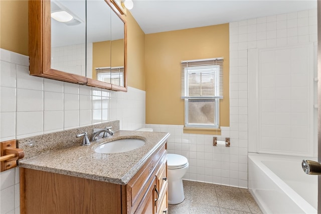 bathroom featuring wainscoting, toilet, tile walls, and vanity