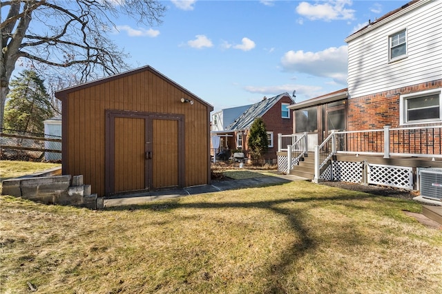 view of shed featuring central AC unit and fence