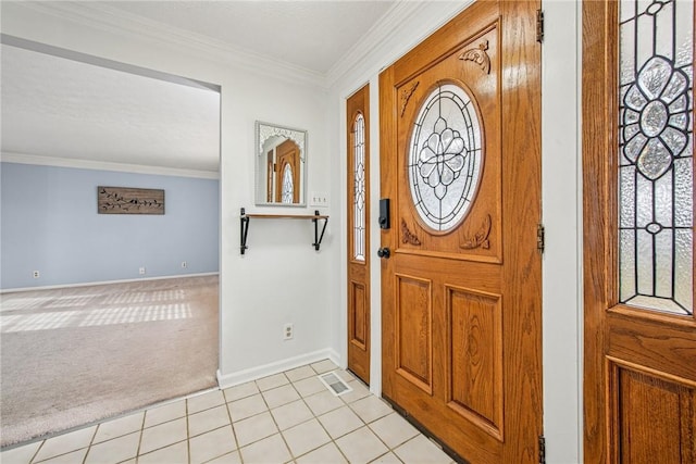 entrance foyer featuring light tile patterned floors, baseboards, light colored carpet, and crown molding