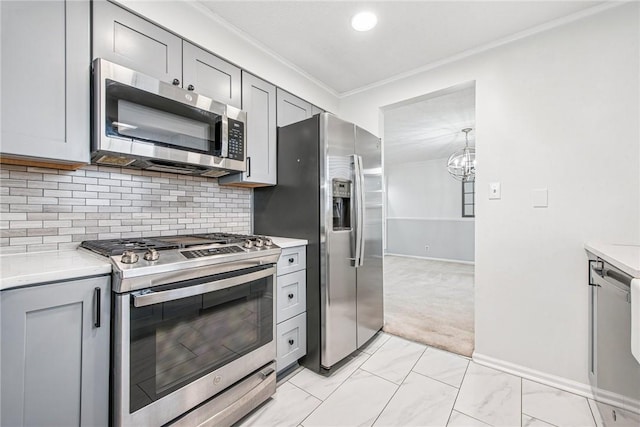 kitchen featuring tasteful backsplash, appliances with stainless steel finishes, ornamental molding, light countertops, and gray cabinetry