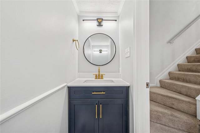 bathroom with ornamental molding, a textured ceiling, and vanity