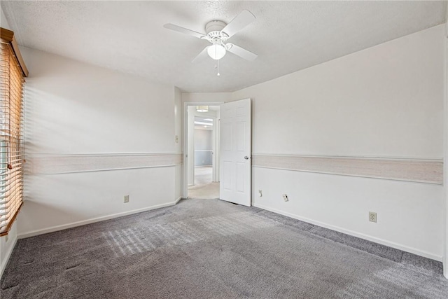 unfurnished bedroom featuring ceiling fan, carpet floors, a textured ceiling, and baseboards