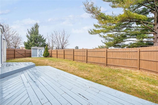 deck featuring a yard, a fenced backyard, a storage shed, and an outdoor structure