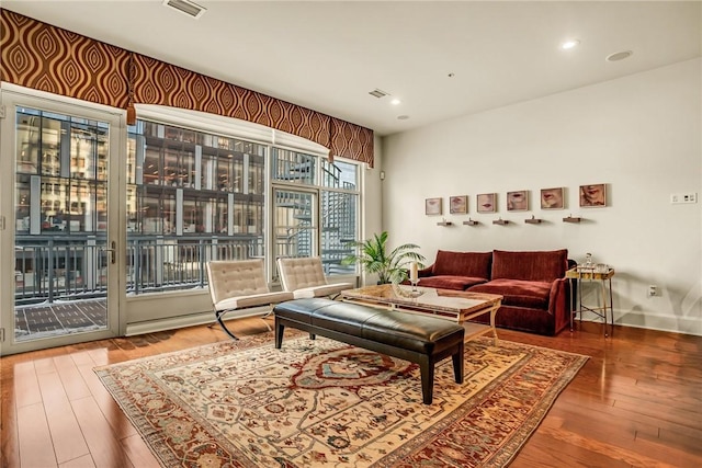 living area featuring baseboards, wood finished floors, visible vents, and recessed lighting