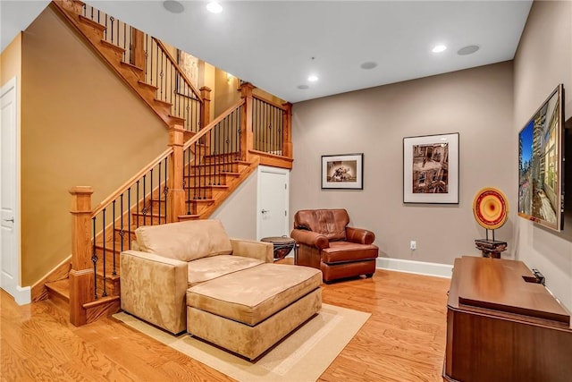 living area featuring stairs, recessed lighting, baseboards, and wood finished floors