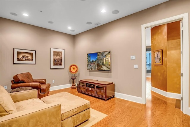 living room with light wood-style floors, baseboards, and recessed lighting