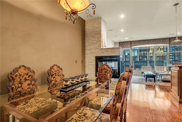 dining space featuring a fireplace, wood finished floors, and recessed lighting