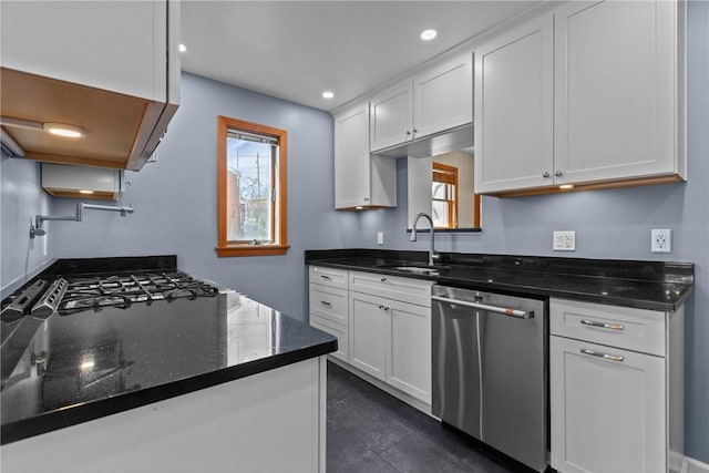 kitchen featuring stovetop, white cabinets, dishwasher, and a sink