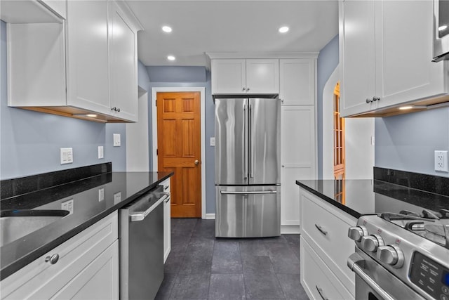 kitchen featuring stainless steel appliances, recessed lighting, white cabinets, and arched walkways