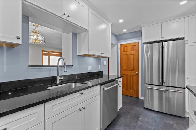 kitchen with appliances with stainless steel finishes, a sink, and white cabinetry