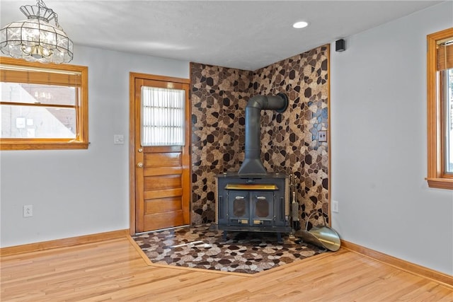 interior space featuring a wood stove, baseboards, wood finished floors, and recessed lighting