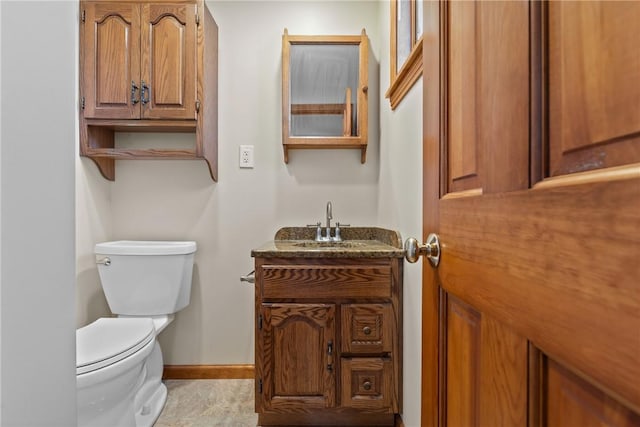 bathroom featuring baseboards, vanity, and toilet