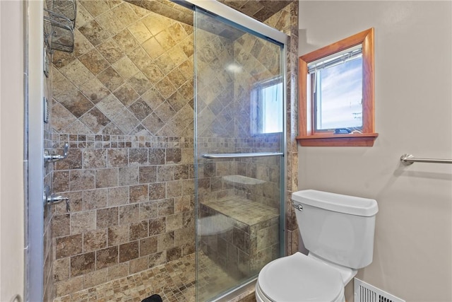 full bathroom featuring a stall shower, visible vents, and toilet