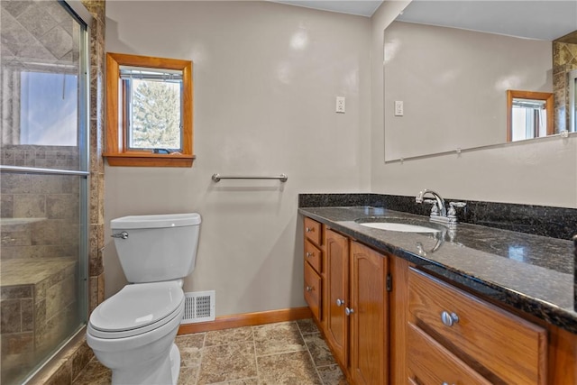 bathroom featuring visible vents, toilet, a shower stall, vanity, and baseboards