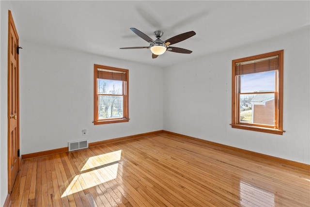 spare room with light wood-style floors, visible vents, plenty of natural light, and baseboards