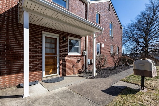 doorway to property with brick siding