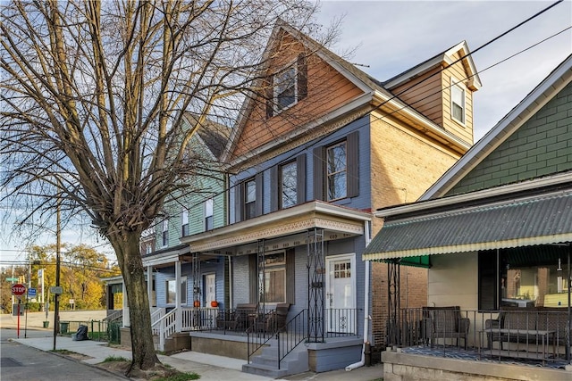 view of front of property featuring covered porch and brick siding