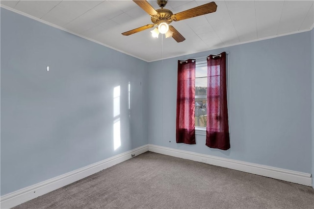 empty room with ornamental molding, carpet, baseboards, and a ceiling fan