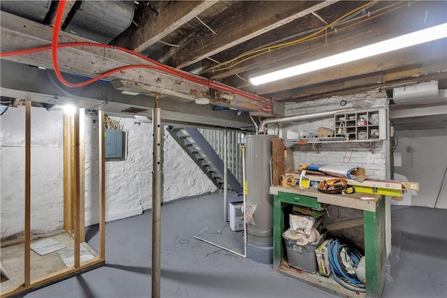 unfinished basement with electric panel, stairway, and water heater