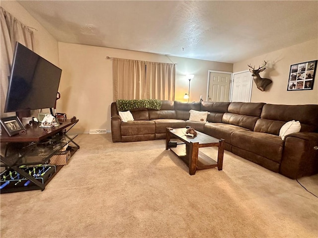 living area featuring visible vents and light colored carpet